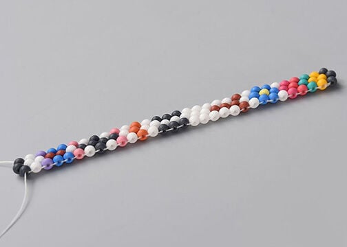Side view of three columns of multicolored seed beads, stitched together.
